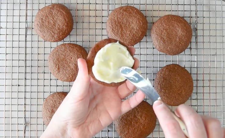 Lemon cream cheese filling is spread on 1 half of a sandwich cookie