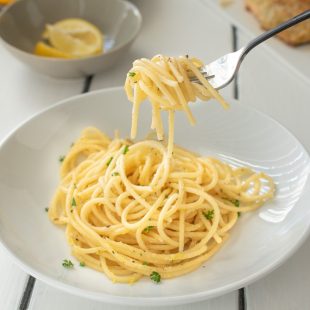 A fork full of spaghetti with lemon and pepper