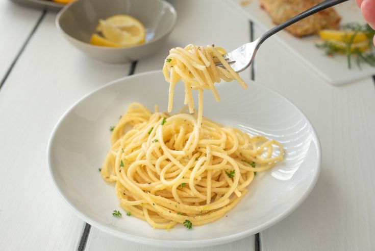 A fork full of spaghetti with lemon and pepper