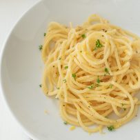 A closeup of lemon pepper spaghetti showing flecks of lemon and parsley