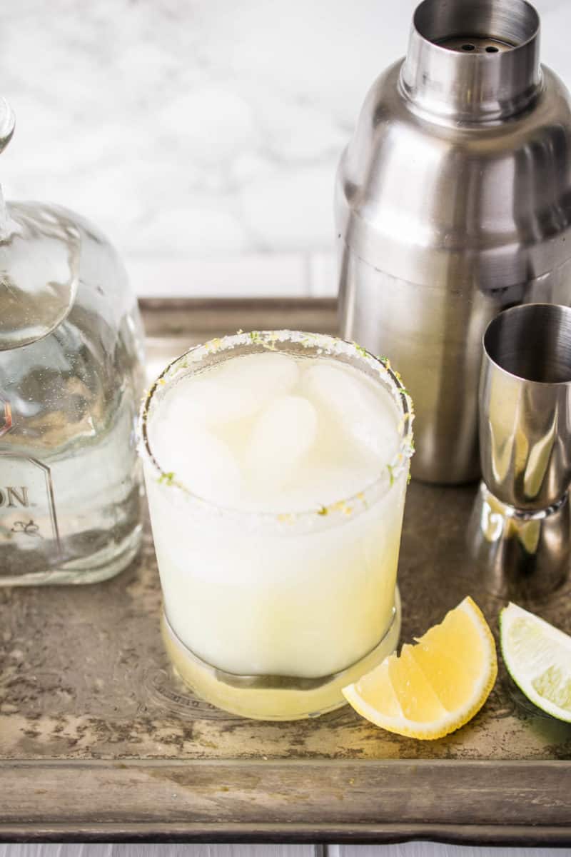 Lemon-lime margarita on a silver tray with tequila and cocktail shaker