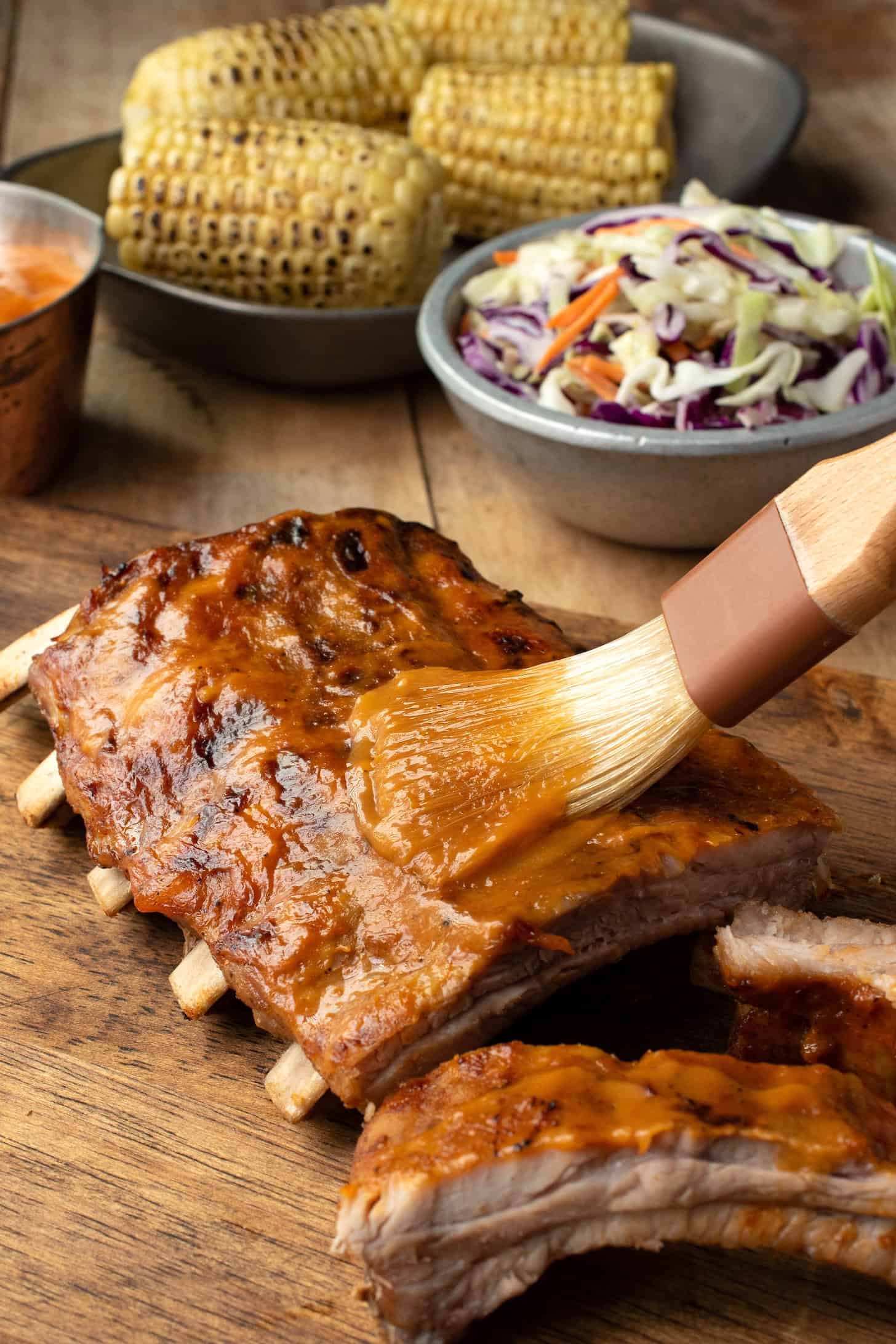 Brushing mango glaze over a rack of ribs
