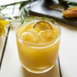 A glass of mango juice with ice and lime slices