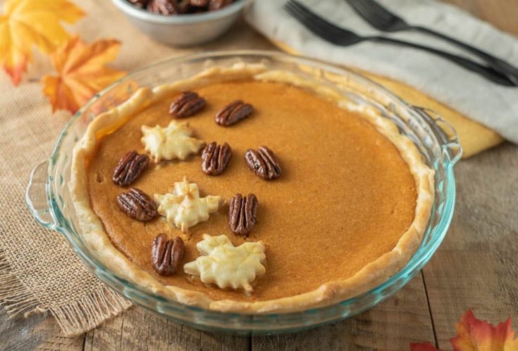 Maple Sweet Potato Pie in a glass pie pan garnished with pastry maple leaves and maple glazed pecans
