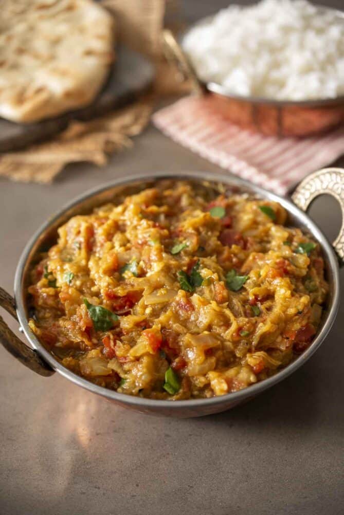An Indian mashed eggplant dish with basmati rice and naan bread