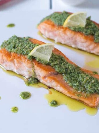 Mediterranean pesto salmon served on a white platter garnished with lemon