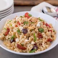 A round white bowl of large couscous