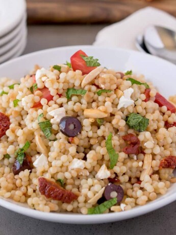 A round white bowl of large couscous