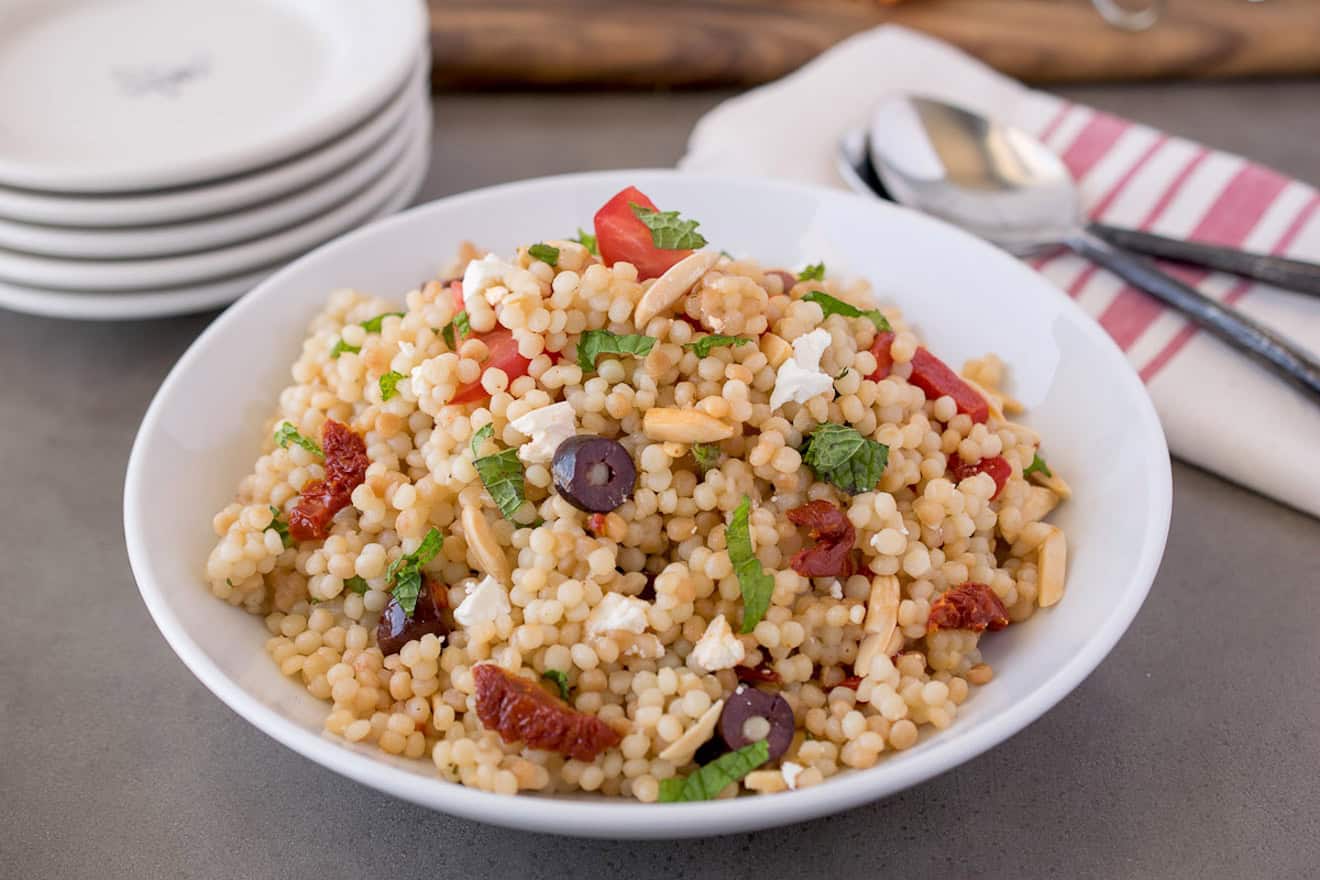 A round white bowl of large couscous