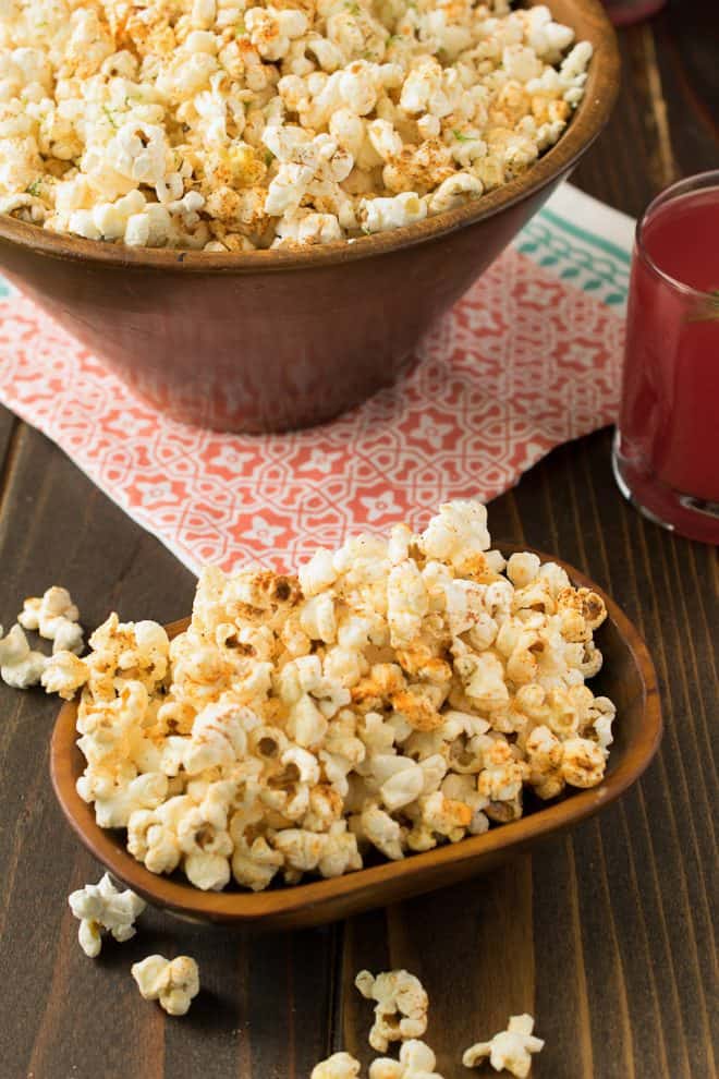 A small wooden bowl and a large round bowl filled with Mexican popcorn