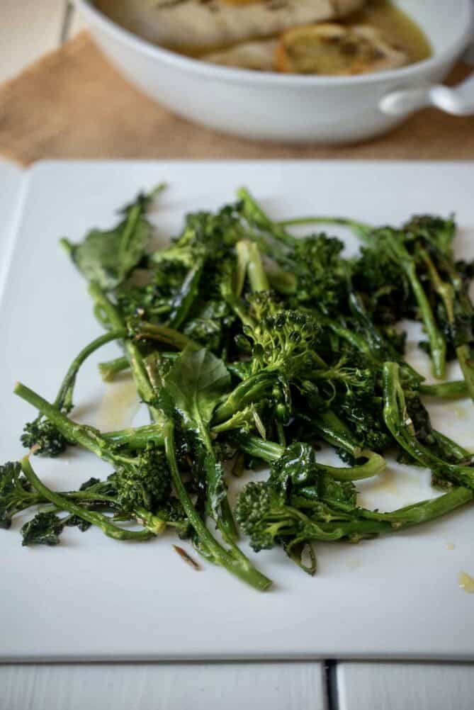 A plate of broccolini drizzled with lemon sauce