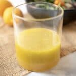 Meyer lemon marinade and dressing in a glass container with a salad