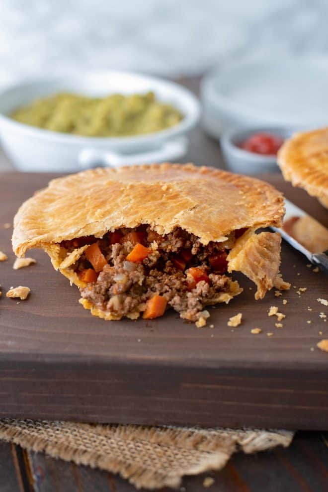A minced beef and onion pie cut open showing the beef and vegetables inside