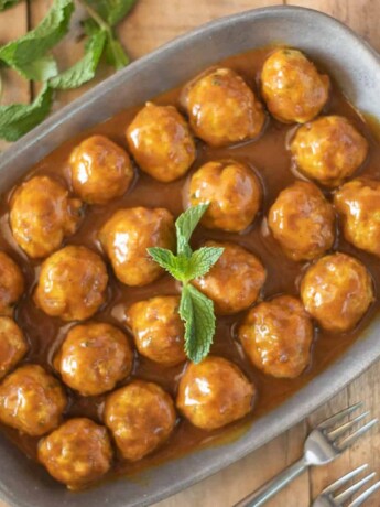 A platter of meatballs in curry sauce viewed from overhead