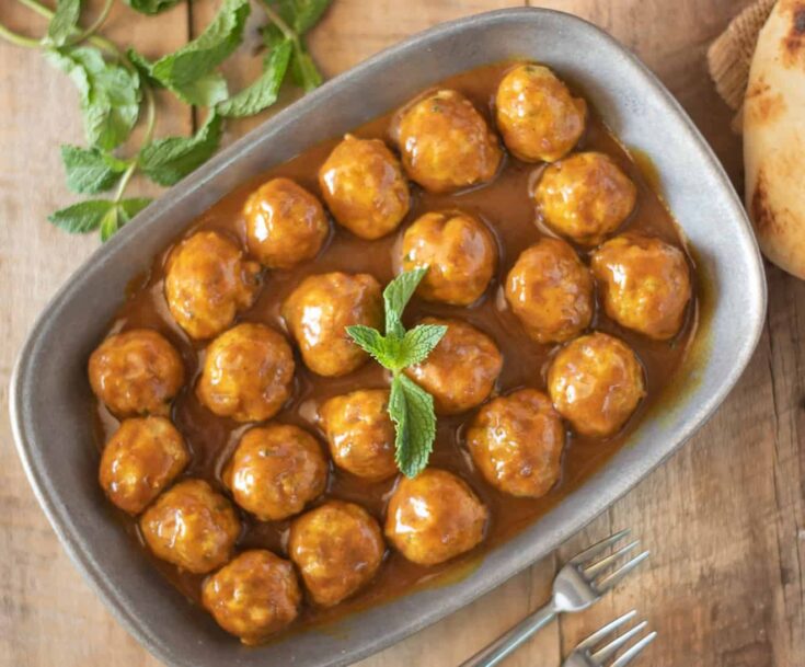 A platter of meatballs in curry sauce viewed from overhead
