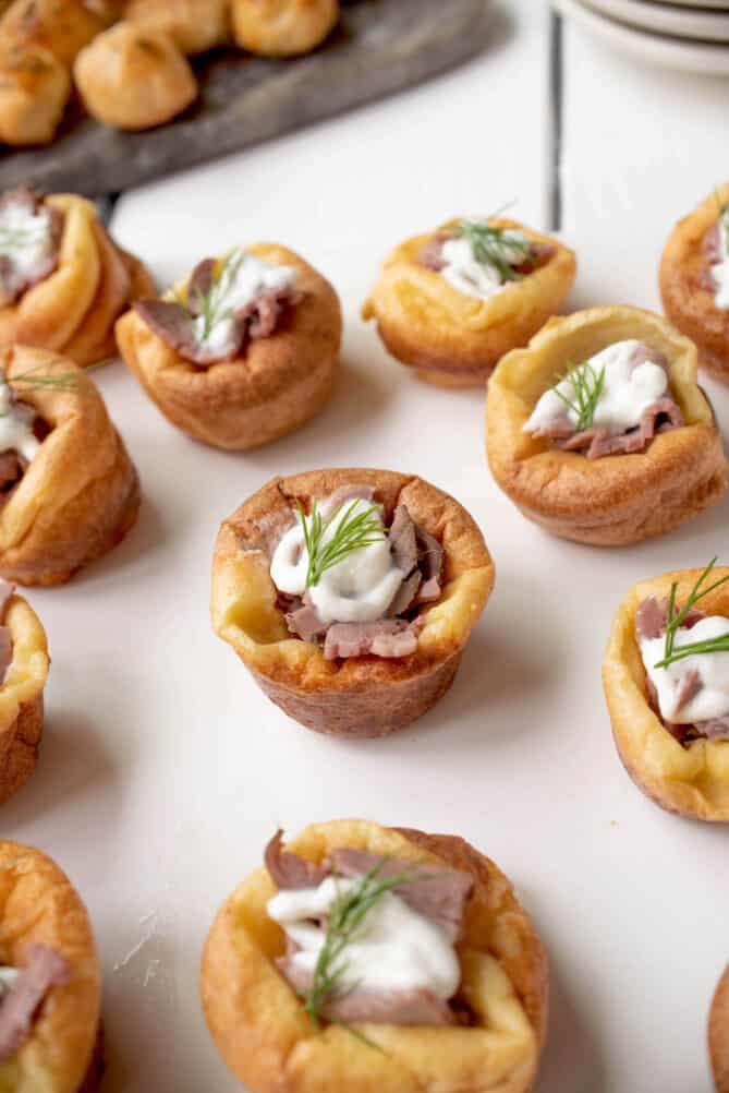 Closeup of a mini Yorkshire pudding with roast beef and horseradish cream sauce