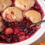 Strawberries, blueberries and blackberries in delicious juices in a white bowl