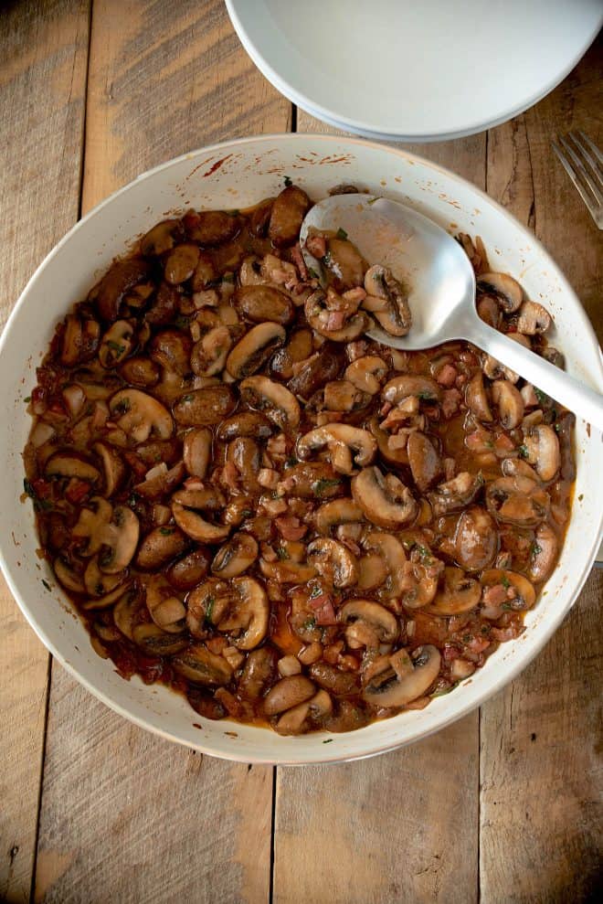 A pan of freshly cooked mushrooms with pancetta.