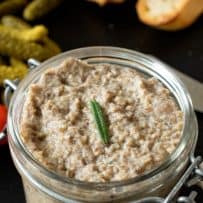 A jar of mushroom pate topped with rosemary
