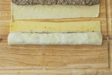 Rolling puff pastry to make sausage rolls