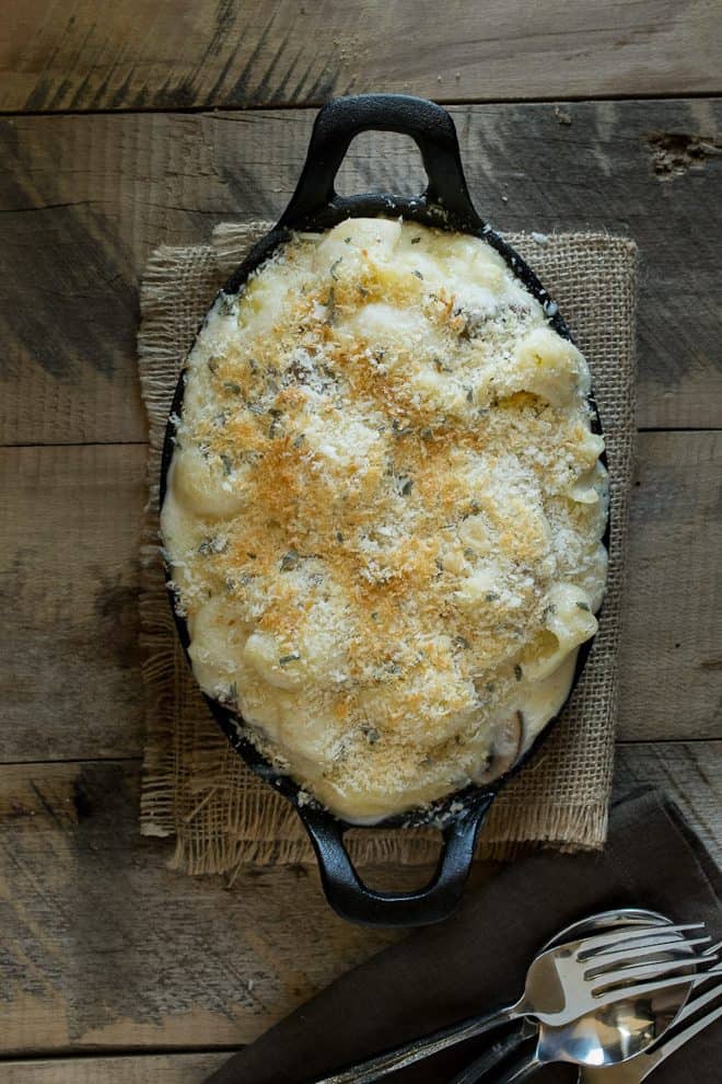 Mushroom sage mac and cheese baked in an oval cast iron skillet