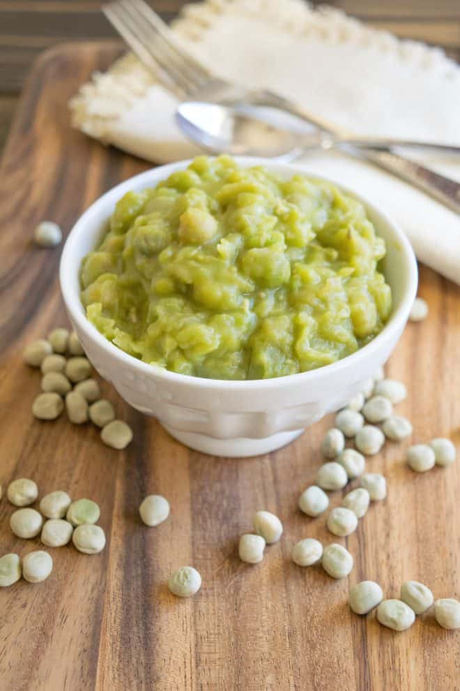 A white bowl filled with mushy peas
