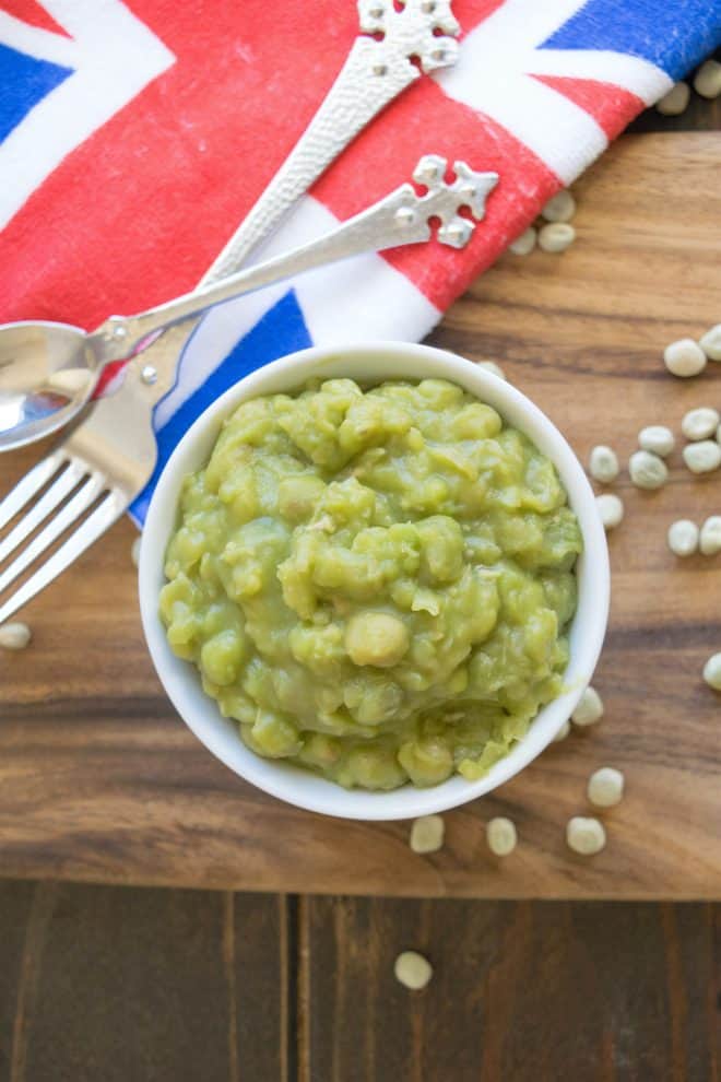 Mushy peas viewed from overhead with a Union Jack towel, a fork and spoon