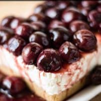 The corner of a no bake cherry lemon cheesecake with beautiful sweet cherries