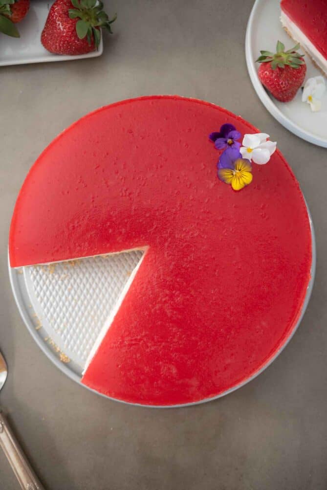 Strawberry cheesecake viewed from overhead with a slice removed