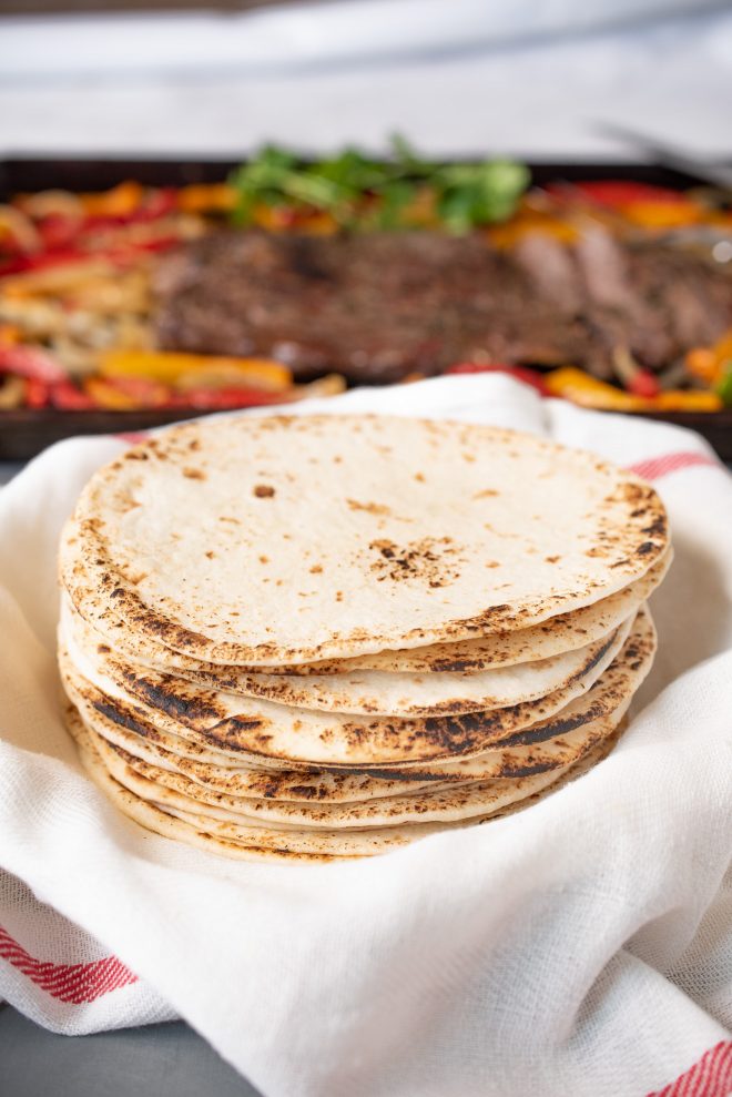 A stack of flour tortillas in a towel to keep them warm