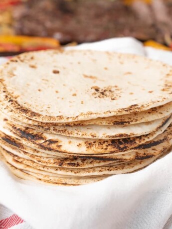 Charred flour tortillas stacked and ready to make tacos