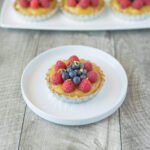 A small tart filled with orange custard topped with berrie
