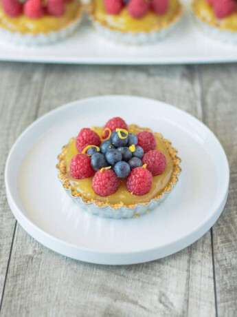 A small tart filled with orange custard topped with berrie