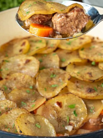 A spoonful of lamb, carrot and sliced potato