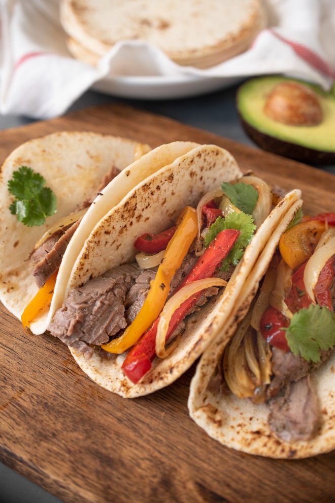 Sliced beef, onions and peppers in tortillas