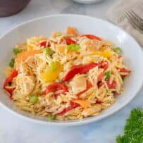 Colorful orange segments, roasted red peppers in an orange chicken orzo salad