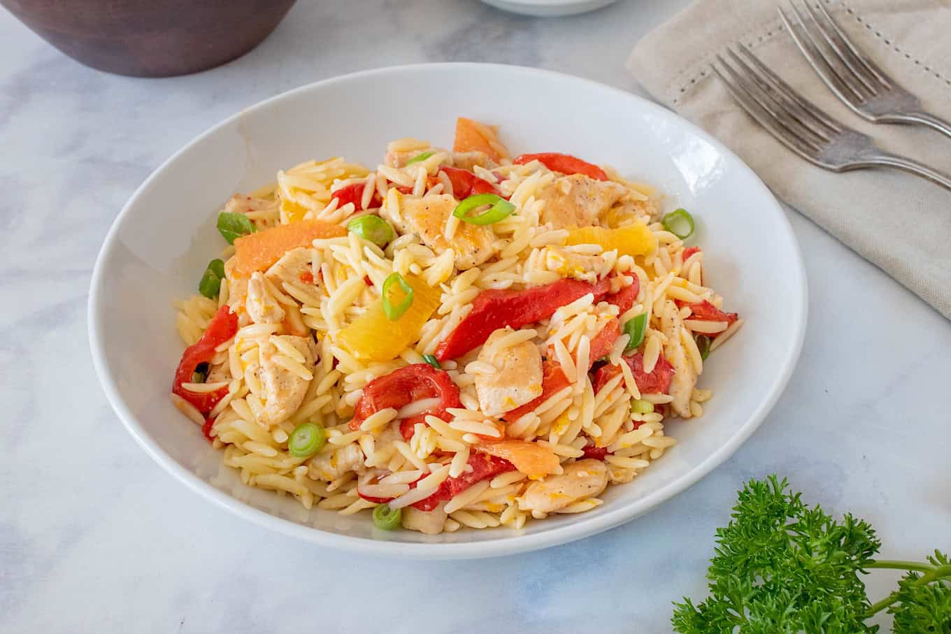 Orzo mixed with orange chicken and vegetables