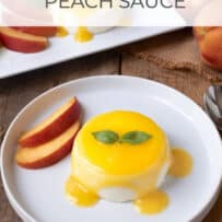 A round, white plate with a round panna cotta drizzled with fresh peach sauce
