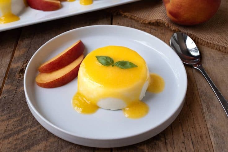 Panna cotta served on a plate with peach sauce
