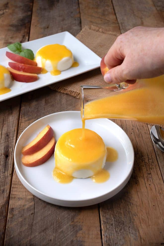 Pouring peach sauce over panna cotta
