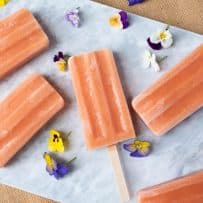 Lovely peach colored popsicles (ice lollies) with pretty flowers for decoration