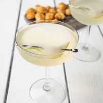 Pear Ginger Champagne Cocktail in a coupe glass with a pear slice on a drink skewer