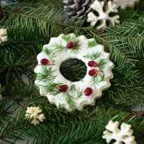 Christmas wreath and snowflake cookies on pine fern with pine cones