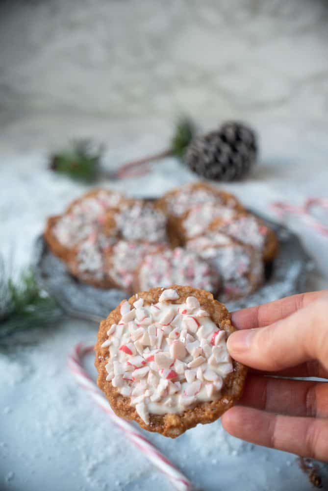 Holding a Florentine lace cookie topped with white chocolate and crushed candy canes