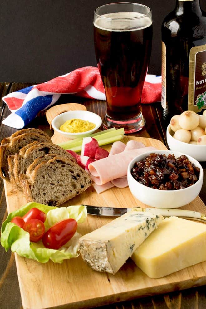 A classic Ploughman's lunch. A board with bread, meats, pickle, cheeses and beer.