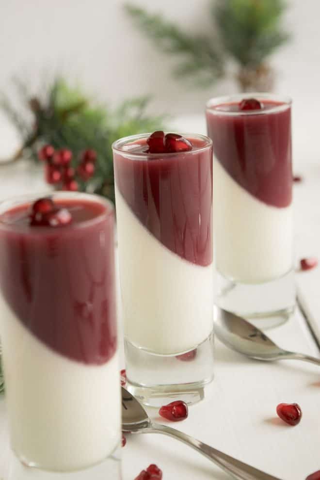 Pomegranate panna cotta decoratively presented in a glass half white and half red