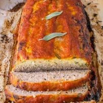 Pork apple and sage meatloaf right out of the oven with fresh sage leaves
