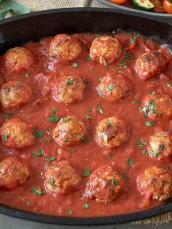 A pan of pork meatballs in a marinara sauce