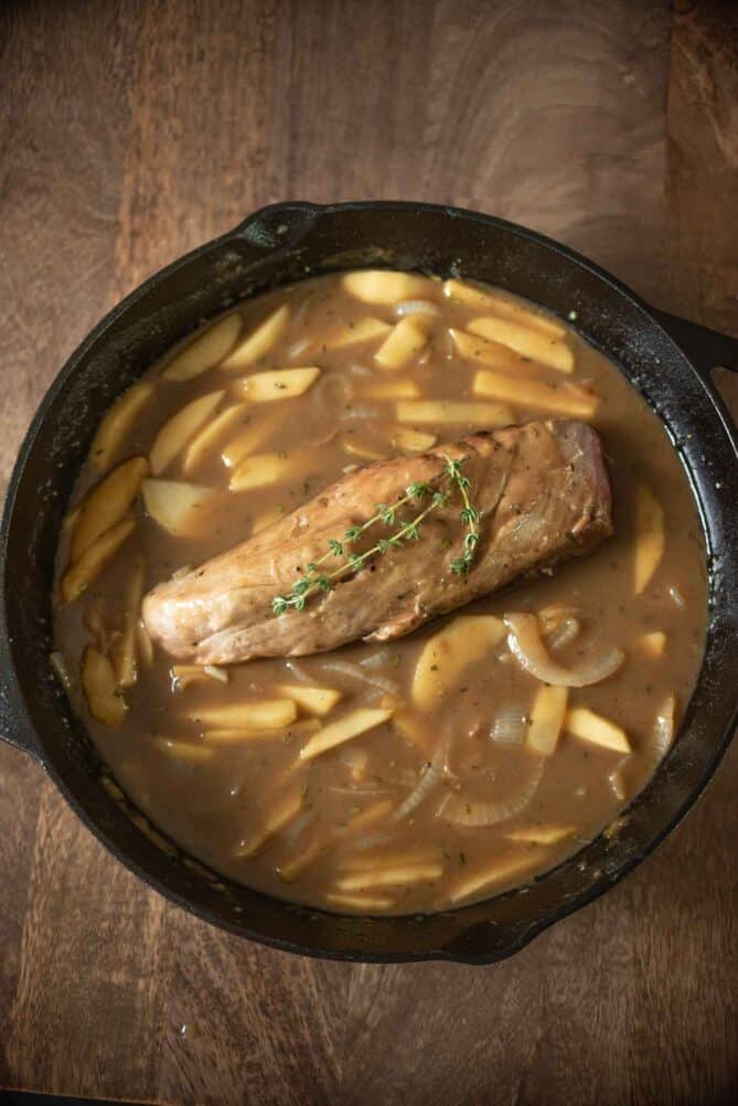 Pork tenderloin with apple and ale gravy in a pan from overhead