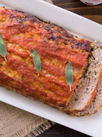 A whole pork apple and sage meatloaf on a long white platter